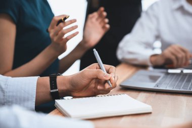 Sekreter, toplantı odasında görüşen bir grup çok ırklı iş adamıyla şirket toplantısında defterine not alıyor. Modern ofiste profesyonel toplantılarda çeşitlilik. Uyum