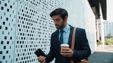 İş adamı telefona cevap verir ve iş yatırımları hakkında konuşur. İş planı, pazarlama stratejisi ya da çalışma hakkında konuşmak için akıllı telefonla konuşurken sokakta yürüyen mutlu bir yönetici. Sevinçli..