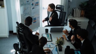Akıllı yönetici projesinin üst görünümü beyaz tahtaya zihin haritası ve finansal grafik ile işaret ediyor ve çeşitli yatırımcılar hisse yatırım grafiğini dinleyip analiz ederken pazarlama fikrini açıklıyor. Müdürlük.