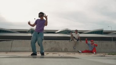 Bir grup Asyalı break dansçı, çok kültürlü arkadaş desteği ve hareketli hip hop müziğiyle sokak dansı yaptılar. Çekici yakışıklı hippi sokak dansında break dansçı. Açık hava sporu 2024. Yumuşak bir şekilde..