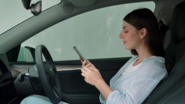 Çevre dostu araba konseptiyle tatil gezisi. EV batarya durumu için boş telif alanı yeşil ekran arabaları tutan sürücü koltuğundaki çevre bilinci olan genç çift. Yükselt