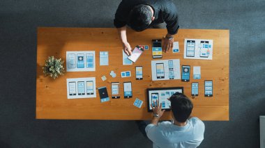 Ux Ui tasarımı üzerinde çalışan yazılım geliştiricisinin en üst görüntüsü. Ekip birlikte çalışarak yaratıcı dijital şirkette wirefram prototipi tasarlıyor. Takım çalışması konsepti. Cemaat.