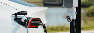 Green City Park 'taki otoparkta EV elektrikli araba şarj bataryası. Sürdürülebilir çevre dostu kentsel yolculuklar için yenilenebilir otomobil için alternatif temiz enerji teknolojisi. Panorama Uygulaması