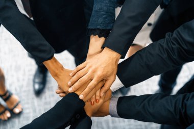 Birçok mutlu iş adamı neşe ve başarıyla el ele tutuşuyor. Şirket çalışanı başarılı bir iş projesini bitirdikten sonra kutlama yapıyor. Şirket ortaklığı ve başarı kavramı. uds