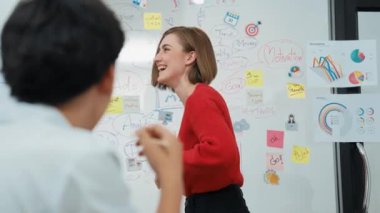 Yetenekli genç ve güzel iş kadını, yaratıcı iş toplantısında yakışıklı yönetici dinlerken zihin haritalama ve istatistiksel grafik kullanarak pazarlama fikrini kendine güvenle sunuyor. Tertemiz..
