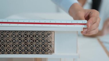 Profesyonel erkek mühendis ev modelini cetvel kullanarak ölçerken güzel bir kooperatif iş arkadaşı verileri analiz etmek için dizüstü bilgisayar kullanarak birlikte çalışıyor. Yaratıcı tasarım ve takım çalışması. - Yakın çekim. Tertemiz..