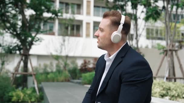 Profesjonalny Biznesmen Noszący Słuchawki Przechodząc Relaksującej Muzyki Zielonym Mieście Biały — Wideo stockowe