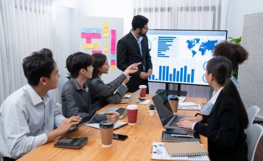 Pazarlama stratejisi için modern toplantıda veri analizi paneli ekranında sunan bir işadamı. Bir grup iş adamıyla konferans odasında iş sunumu. Uyum