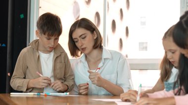 Çizim kitabında işaret kullanarak çeşitli öğrencilerin ve zeki öğretmen çizimlerinin panorama çekimi. Sanat dersinde çizim kitabını kullanarak çok kültürlü bir öğrenci. Rahatlama. Etkinlik.