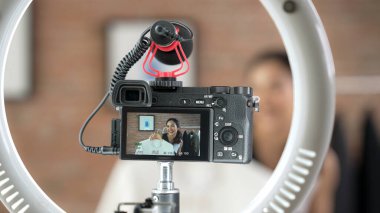 Arka görünüm, kamera ekranında kadın nüfuzunu gizler. Video görüntüleme, video görüntüleme, giysi, sosyal medya ya da blog. Canlı yayın için canlı stüdyo ışıklandırması olan kız canlı yayın pazarlama kaydı