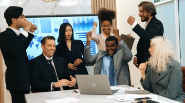 Çeşitli ofis çalışanları ve çalışanları, iyi bir takım çalışması ve olumlu tutum sergiledikleri için sevinçli ve heyecanlı bir kutlamayla ellerini kaldırarak, süslemeli işyerindeki ticari başarıya katkıda bulunurlar.