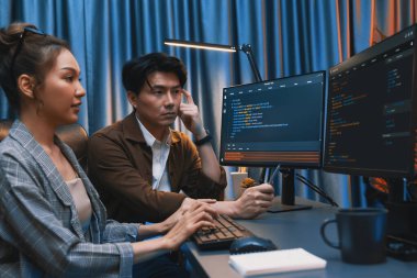 Bilgi teknolojisi geliştiricileri modern ofisteki neon ışık odasında verileri çevrimiçi olarak çalıştıran akıllı web sitesi geliştirme kodlayıcı sistemine işaret ediyorlar. İnfobahn.