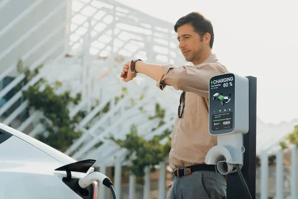Ung Man Kontrollerar Tiden Smartwatch Medan Laddare Att Ladda Batteriet — Stockfoto