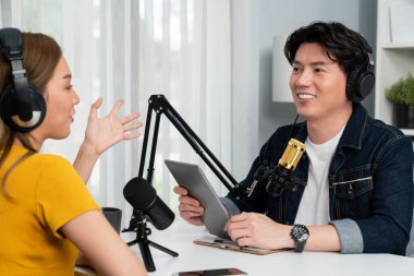 Gülümseyen radyo etkili sunucu elinde tablet, kulaklık takıyor kadın konuşmacı sosyal medya online canlı yayın kanalı ile röportaj yapıyor ve sabah stüdyo kaydında paylaşım linkini paylaşıyor. İnfobahn.