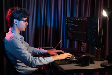 Uygulama pc ekranları ile çevrili çevrimiçi yazılım geliştirme bilgilerini yoğunlaştıran IT geliştiricisi, neon modern ofis evindeki web sitesinde yazılım için program yaratıyor. Toplayıcı.