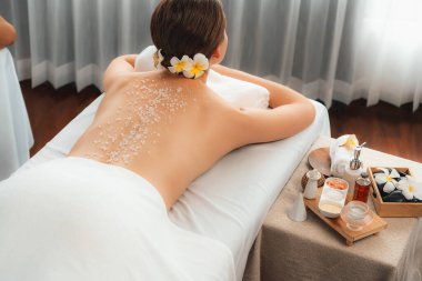 Lüks spa salonlarında sıcak mum ışığında cilt bakımı yaptıran kadın müşteri. Sağlık Spa vücut fırçasında tuz temizleme güzellik tedavisi. Sessiz.