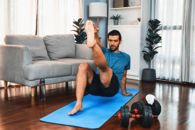 Atletik ve sporcu adam, evde vücut egzersizi yaparken spor ve spor yaşam tarzına uyum sağlamak için spor minderinde çatırdıyor. Gaiety ev egzersizi antrenman konsepti.