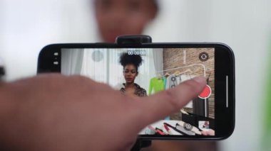 Kadın nüfuzlu kişi canlı yayında video görüntülerini çekiyor. Kıyafetler sosyal medya ya da blog için çok önemli. Stüdyo ışıklandırmalı mutlu genç kız çevrimiçi pazarlama oturumu yayını için..