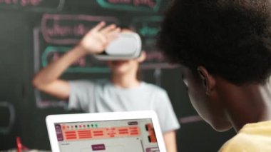 Afrikalı erkek programlama sistemi, beyaz bir kız karatahtanın başında mühendislik kodlarıyla otururken metaverse 'e giriyor. Liseli kız STEM teknolojisinde VR ya da kulaklık takıyor. Öğretim