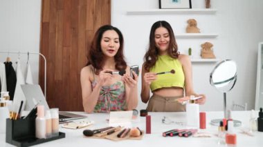 Etkilenen iki ortak canlı yayın yapan video görüntülerini sosyal medya ya da blog üzerinden gözden geçirir. Canlı kozmetik stüdyosu ışıklandırması olan mutlu genç bir kız pazarlama için internet üzerinden yayın yapıyor..