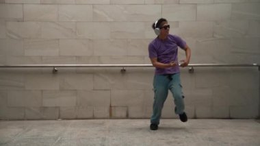Yakışıklı hippi dans ederken müzik dinler ya da dans ederken dans eder. Çekici bir sokak dansçısı B-boy ayak sesleri çıkarıyor. Serbest dans konsepti. Yaşam tarzı. Açık hava sporu 2024. Yumuşak bir şekilde..