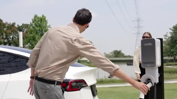 Das Junge Paar Lädt Die Elektroauto Batterie Einer Ladestation Auf — Stockvideo