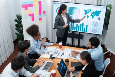 Modern toplantı odasındaki TV ekranında veri analizi paneliyle üst görünüm iş sunumu. İş adamlarının iş pazarlama stratejisini planlamak için beyin fırtınası yapması ya da birlikte çalışması. Uyum