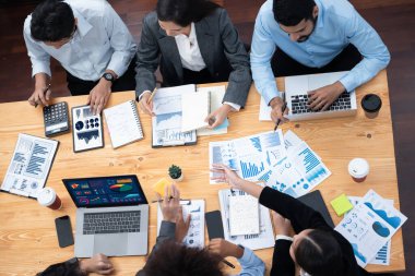 Çok ırklı analist ekibi toplantıdaki finansal verileri analiz etmek için BI Fintech yazılımı kullanıyor. Üst görünüm finans paneli veri ekranında pazarlama göstergesi için analiz edilmiş grafikle birlikte. Uyum