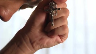 Hristiyan katolik takipçilerle dinsel bağlılık ve maneviyat duygusu doludur. Ağır çekimde Hristiyan, Tanrı 'ya ibadet etmek için dua ederken kutsal haçı tutuyor. Filizlenen