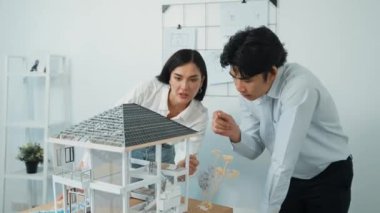 Profesyonel kooperatif beyaz mimar mühendis ekibi ev modelini dikkatle incelerken beyaz modern ofisteki model yapısı hakkında tartışırlar. Yaratıcı karar ve takım çalışması. - Yakın çekim. Tertemiz..
