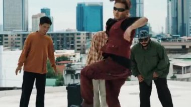 Çatıda çok kültürlü arkadaşlar varken profesyonel İspanyol break dansçısı B boy dansı. Genç modern dans grubu hip hop hareketi yapıyor. Tarz, moda, aksiyon. Açık hava sporu 2024 hiphop..