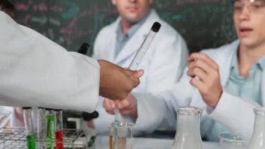 Çalışmaya hazırlanmak için kız eliyle biyokimyasal test tüpünü seçiyor. Zeki öğretmen ve bir grup mutlu çocuk BTMM fen sınıfında teoriyle kara tahtada deney yapıyorlar. Öğretim