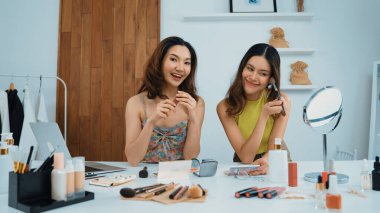 Etkilenen iki ortak canlı yayın yapan video görüntülerini sosyal medya ya da blog üzerinden gözden geçirir. Canlı kozmetik stüdyosu ışıklandırması olan mutlu genç bir kız pazarlama için internet üzerinden yayın yapıyor..