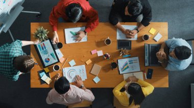 İş kadını tabletinin en üst görüntüsü finansal grafik ve toplantı masasında yapışkan notlarla duruyor. Proje yöneticisi borsa istatistiklerine ve veri analizlerine bakıyor. Cemaat.