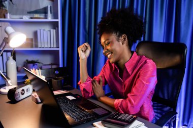 Mutlu, ışıldayan, gülümseyen yüzlü, çalışan Afrikalı bir kadın, iyi bir anlaşma ile yeni bir iş projesi alıyor ya da bilgisayar ekranında burs bilgilerini pazarlıyor. Neşeli ifade anlayışı. Tatlandırıcı.