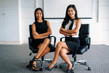 Ofiste oturan iki genç Asyalı iş kadını. İş arkadaşları ve toplum konsepti. uds