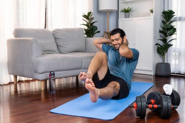 Atletik ve sporcu adam, evde vücut egzersizi yaparken spor ve spor yaşam tarzına uyum sağlamak için spor minderinde çatırdıyor. Gaiety ev egzersizi antrenman konsepti.