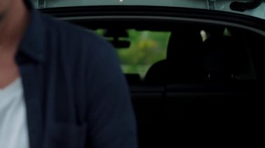 Ulusal Park veya Yaz Ormanı 'ndaki tatil gezisi sırasında EV şarj istasyonundan elektrik aküsü almak için akıllı telefon internet bankacılık uygulaması kullanan bir adam. Yükselt