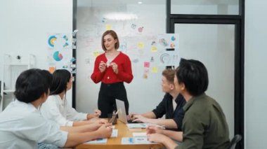 Yetenekli genç ve güzel iş kadını, yaratıcı iş toplantısında yakışıklı yönetici dinlerken zihin haritalama ve istatistiksel grafik kullanarak pazarlama fikrini kendine güvenle sunuyor. Tertemiz..