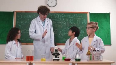 Öğretmen yeni fikirleri ya da yenilikleri kutlamak için mutlu çocuklara beşlik çakıyor. Zeki bilim adamları ilham verir ya da heyecan verici öğrencileri deneyim kazanmaları için teşvik eder. Pedagoji.