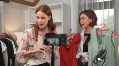 İki kadın nüfuzlu kişi canlı yayın yapan video klip eleştirisi kıyafetlerini sosyal medyada ya da blogda yayınlıyor. Stüdyo ışıklandırmalı mutlu genç kız çevrimiçi pazarlama oturumu yayını için..