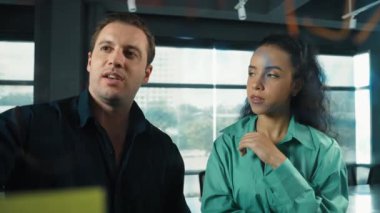 Yetenekli işadamı pazarlama fikrini cam duvardaki proje yöneticisine sundu. Yönetici projeyi yatırımcıya açıklıyor. Zeki iş adamları birlikte çalışıyor, beyin fırtınası yapıyorlar. Yönlendirici.