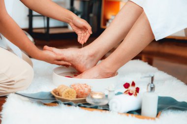 Adam lüks kaplıcalarda mutlu ayak masajına devam ederken, masör de hafif gün ışığı atmosferinde refleksoloji terapisi ya da otel ayak spa 'sında. Sessiz.