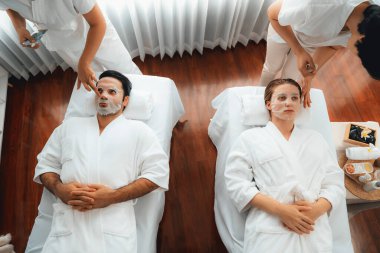 Kaplıca salonunun sakin, modern gündüz atmosferi, birkaç müşteri yüz maskesi takarak kendini yenilemeye çalışıyor. Yüz bakımı ve güzellik kozmetolojisi prosedürü. Sessiz.