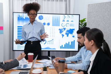 Genç Afrikalı iş kadını modern toplantıda TV ekranında veri analizi paneli sunuyor. Bir grup iş adamıyla konferans odasında iş sunumu. Uyum