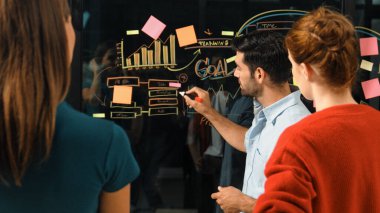 Akıllı yatırımcılara pazarlama fikri ya da finansal planı sunan profesyonel iş adamı. Yönetici yönetici paylaşıyor, konuşuyor, kooperatif iş arkadaşlarıyla birlikte çalışıyor. İş konsepti. İzleme