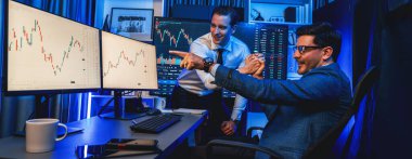 Borsa simsarları panorama manzaralı yüksek kar tablosu yatırımlarına bakıyor, geceleri monitörde analiz ediyorlar. İş yerinde finansal teknoloji gelişimini neon ışığında tartışma kavramı. Satılabilir.