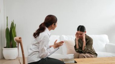 Psikologla ruh sağlığı terapisi gören üzgün travma sonrası stres bozukluğu olan bir kadın. Yaşam sonrası depresyon veya keder. Hayal kırıklığına uğramış genç bir kadın klinikteki duygular hakkında Vivancy psikoloğuyla konuşuyor.