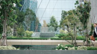 Koşarken ve bavulunu tutarken Eko Park 'taki önemli bir randevuya yetişmek için acele eden müdürün yan görüntüsü. Endişeli erkek lider saate bakarken saati düşünür. Yaşam tarzı. Urbane.