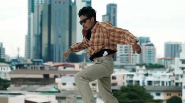 İspanyol break dansçı B-boy dansçısının ayak seslerini şehir manzaralı ya da gökdelenli çatıda pratik yapıyor. Genç modern dans grubu hip hop hareketi yapıyor. Tarz, moda, aksiyon. Açık hava sporu 2024 hiphop..